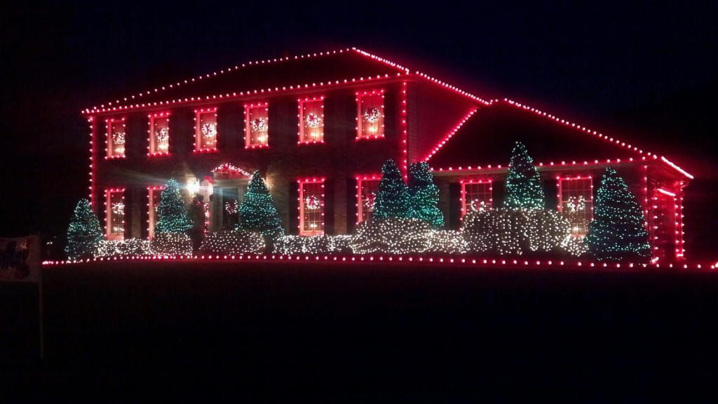 two story house decorated with red holiday lights