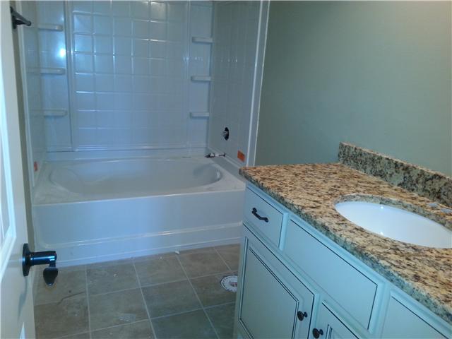 Second bathroom with large garden tub and granite sink top