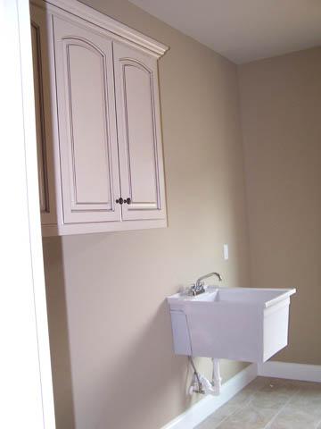 Large laundry room with built-in cabinets and utility sink 